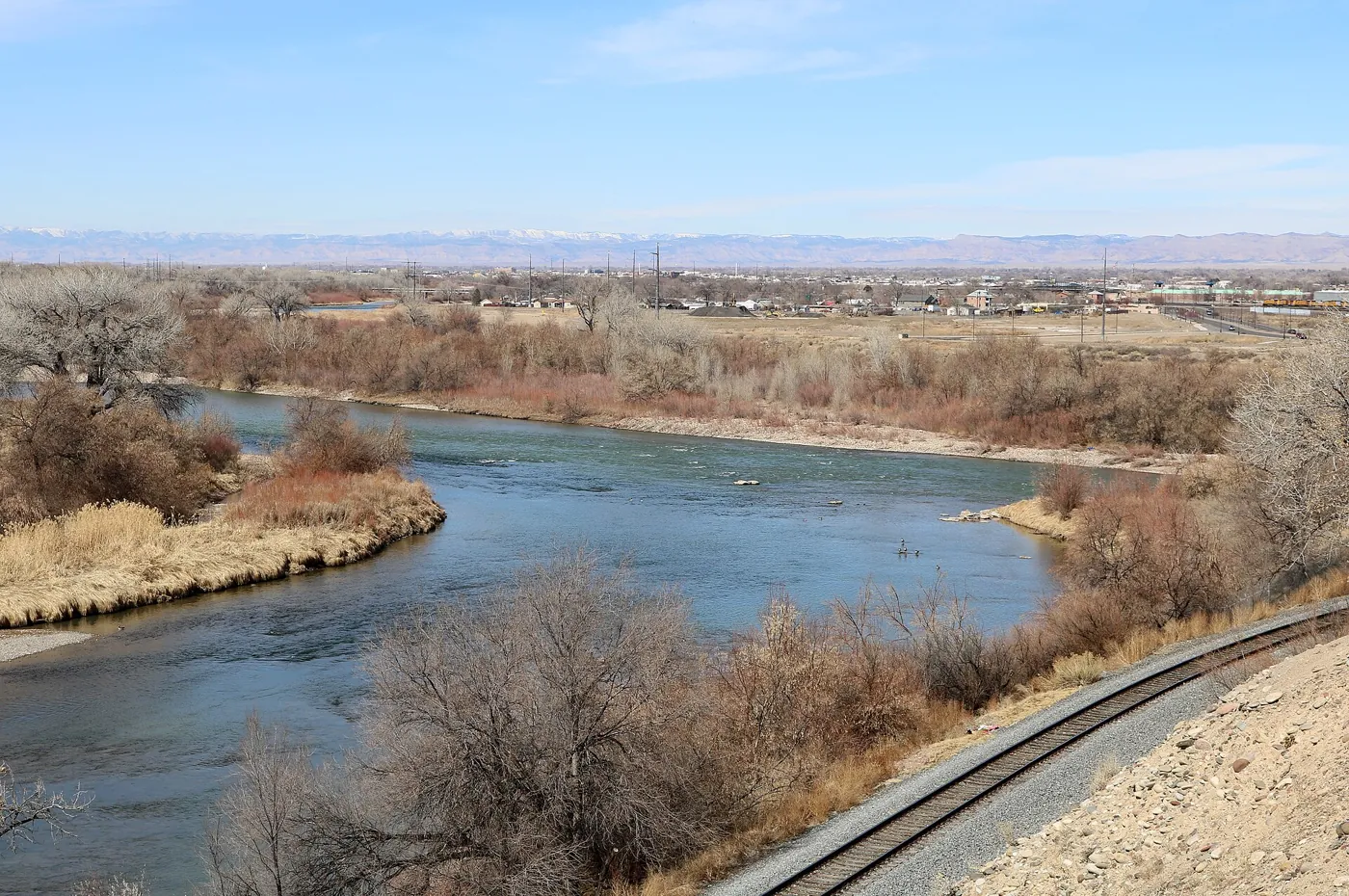 The Gunnison and Colorado rivers meeting beside railroad tracks in Grand Junction
